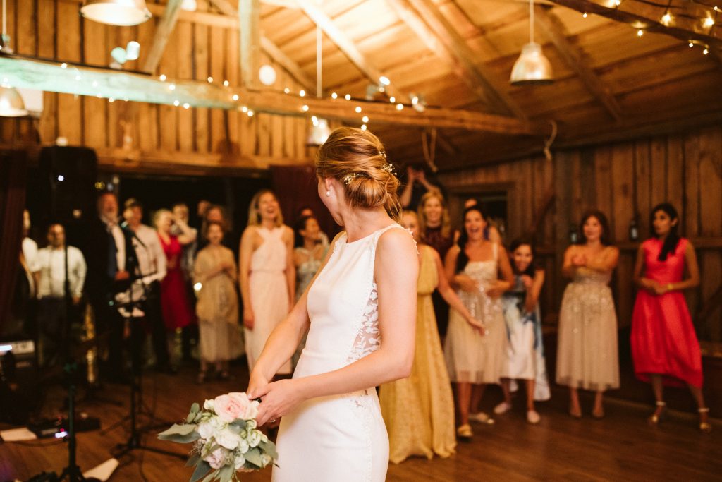 Morsiusneito heittää kukkia päänsä yli Calliolan häissä, aivan Suomen saaristomeren rannalla.